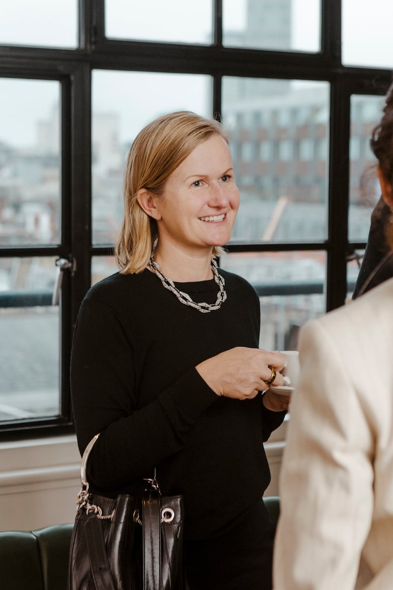 Headshot of Helene Phillips, chief client officer at Jimmy Choo, holding a coffee cup.