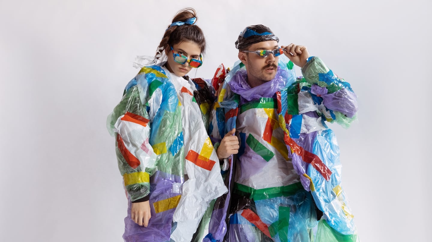 A woman and man wear clothes made from plastic bags.