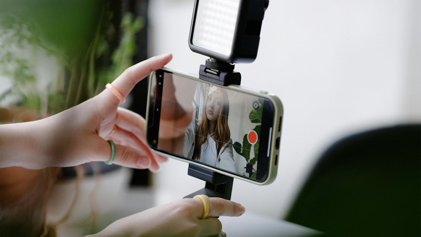 A person setting up a camera to record a video.