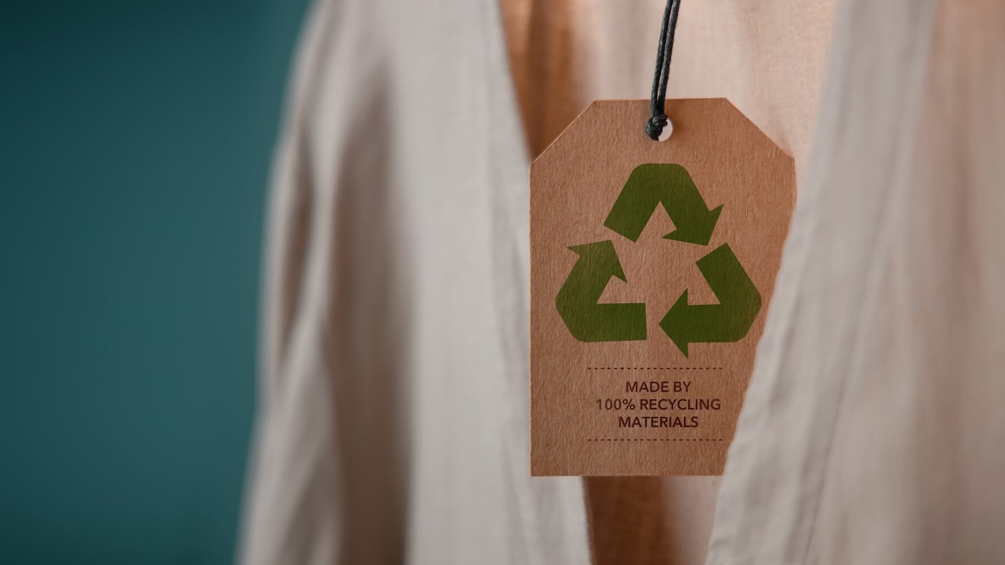 A 100% recycled label hangs from a white shirt.