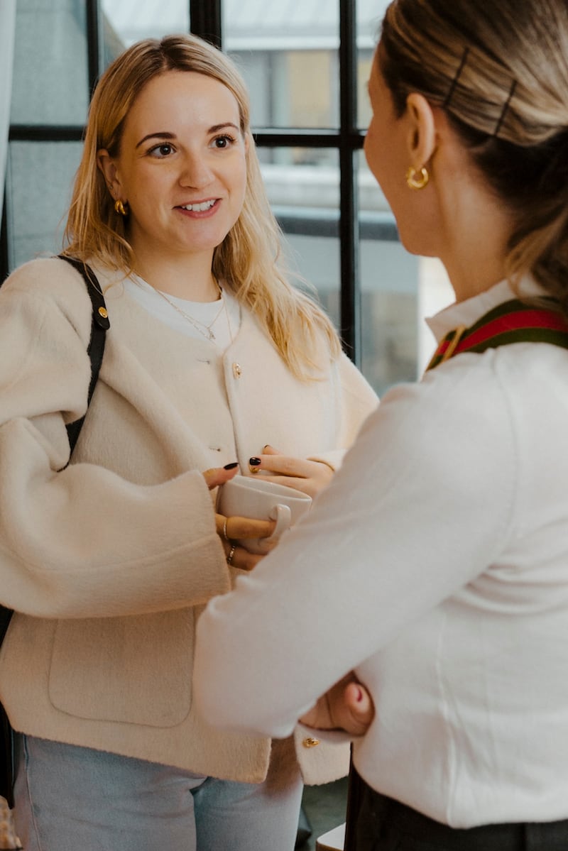 Headshot of Alex Rowand, senior marketing manager at Russell & Bromley, holding a coffee cup.